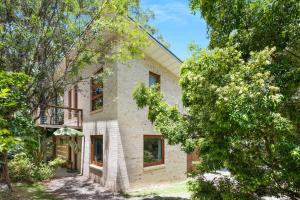 a brick house with trees in front of it at Sweeds - Belle Escapes Jervis Bay in Vincentia