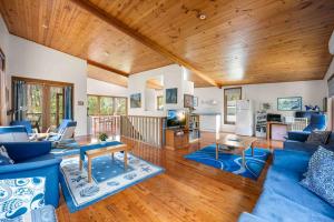 a living room with blue couches and a wooden ceiling at Sweeds - Belle Escapes Jervis Bay in Vincentia