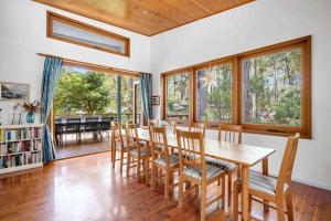 a dining room with a wooden table and chairs at Sweeds - Belle Escapes Jervis Bay in Vincentia +8 photos