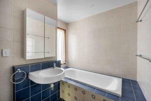 a bathroom with a tub and a sink at Sweeds - Belle Escapes Jervis Bay in Vincentia