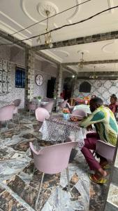 a man sitting at a table in a room at Skyatlantic guesthoüse in Douala