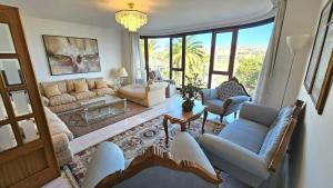 een woonkamer met banken, stoelen en ramen bij Luxury 3lvl House in Telde