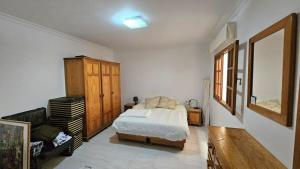 een slaapkamer met een bed en een houten kast bij Luxury 3lvl House in Telde