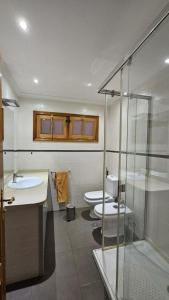 een badkamer met 2 toiletten en een glazen douche bij Luxury 3lvl House in Telde +25 foto's