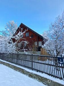 Ujsoły Chill House في ويسولي: منزل خشبي مع سور في الثلج