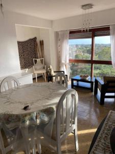Departamento 3 ambientes a 2 cuadras del mar y Avenida Bunges في بينامار: غرفة معيشة مع طاولة وكراسي بيضاء