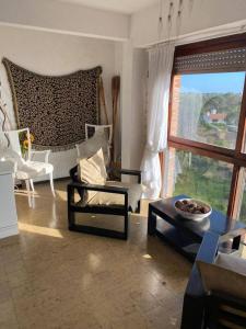 Departamento 3 ambientes a 2 cuadras del mar y Avenida Bunges في بينامار: غرفة معيشة مليئة بالأثاث ونافذة كبيرة