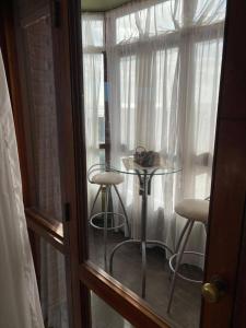 Departamento 3 ambientes a 2 cuadras del mar y Avenida Bunges في بينامار: غرفة بها طاولة وكرسيين في النافذة +3 صور