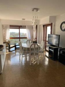 Departamento 3 ambientes a 2 cuadras del mar y Avenida Bunges في بينامار: غرفة طعام مع طاولة وكراسي وتلفزيون