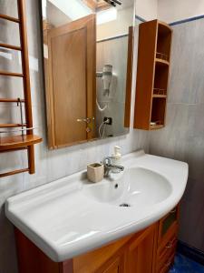 Un baño con un lavabo blanco y un espejo. en Grand Gaeta, en Roma 101 fotos más