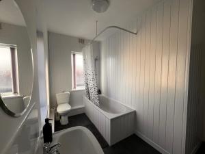 un bagno bianco con vasca e WC di Just Stay 2 a Warrington Altre 13 foto
