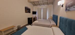 ein Hotelzimmer mit zwei Betten und einer Couch in der Unterkunft Hotel Rural Atalaya in Guadalupe