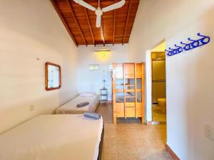 Casa San Miguel Frente al Mar في San Silvestre: غرفة نوم بسريرين وغرفة بدولاب