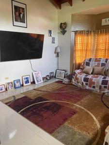 a living room with a flat screen tv and a couch at A taste of M&M in Belize City