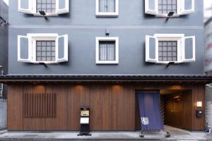 a building with two windows and a door with a sign on it at Hotel Matsunoi Shurin in Tokyo