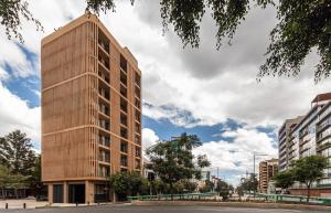 un edificio alto de madera en una ciudad en Kukun Edition Marsella Juarez, en Ciudad de México