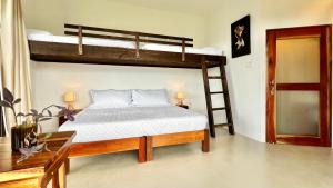 a bedroom with two bunk beds and a desk at Searenity Octopus Cottage in Port Antonio