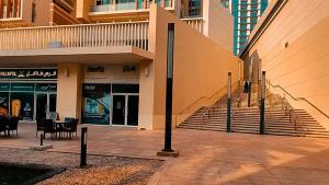 Panoramic B8 Sea View two bedroom apartment في أبوظبي: مبنى امامه درج وطاولة +9 صور