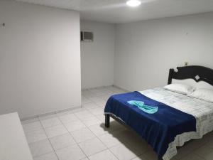 een slaapkamer met een bed met een blauwe deken erop bij Ouro branco Mossoró RN in Mossoró