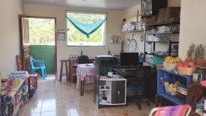 a room with a desk and a table with a window at Quarto do Sol Relaxante - 150m da praia in Ubatuba +4 photos