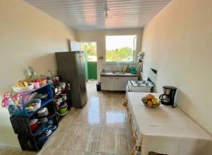 a kitchen with a table and a refrigerator in it at Quarto do Sol Relaxante - 150m da praia in Ubatuba