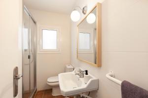 a bathroom with a sink and a toilet and a mirror at Casa Rosari I - Jardín & Parking Privado in Vilassar de Mar +10 photos
