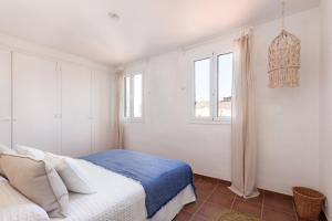 a white bedroom with a bed and a window at Casa Rosari I - Jardín & Parking Privado in Vilassar de Mar
