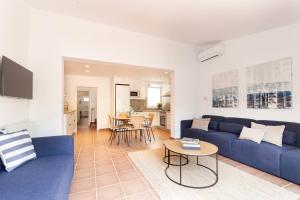a living room with a blue couch and a table at Casa Rosari I - Jardín & Parking Privado in Vilassar de Mar