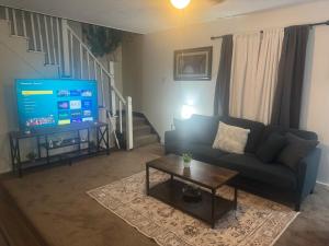 Cozy 3 4 BR Home Ideal for Family في كلاركسبورغ: غرفة معيشة مع أريكة وتلفزيون