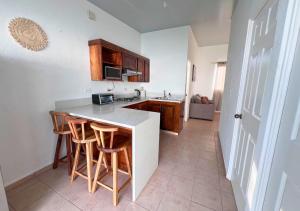 - une cuisine avec un comptoir et quelques tabourets dans l'établissement Colibri de Montaña, à Ahuachapán