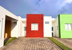 une rangée de maisons aux murs rouges et verts dans l'établissement Colibri de Montaña, à Ahuachapán