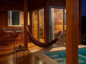 a room with a hammock and a swimming pool at luxury wooden house mountain view in Hojancha
