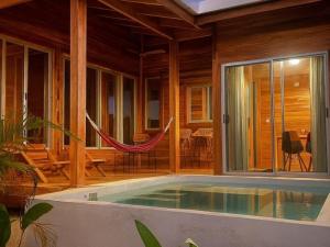 a house with a pool and a hammock in it at luxury wooden house mountain view in Hojancha