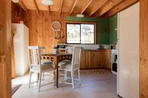 a kitchen with a table and chairs in a room at Geoff's - beach, bush and bliss in Saint Helens Island