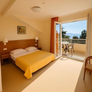 una habitación de hotel con cama y balcón en Hotel Neptun Gradac, en Gradac