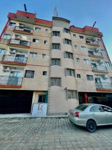 a car parked in front of a large building at Loft Residence in Douala