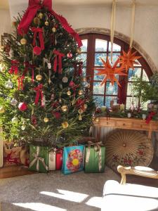 a christmas tree with presents under it in a room at Mas de Kyoto, Maison d'hôtes l'expérience Japonaise in Dions