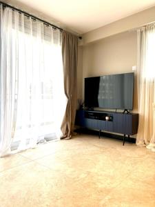 a living room with a flat screen tv and windows at Appartement cosy proche de la Croisette et du Palais des Festivals in Cannes