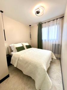 a bedroom with a white bed and a window at Appartement cosy proche de la Croisette et du Palais des Festivals in Cannes