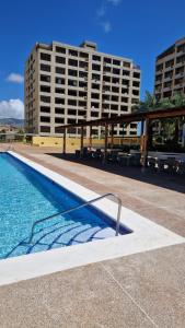 a swimming pool in front of a large building at Apartamento Isla de Margarita in Pampatar