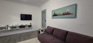 a living room with a couch and a flat screen tv at Straja Nest in Lupeni