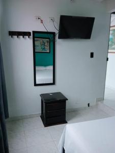 a room with a mirror and a dresser and a bed at Casa Hotel El Eden in Carepa