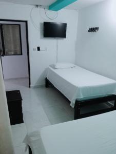 a hospital room with a bed and a tv on the wall at Casa Hotel El Eden in Carepa