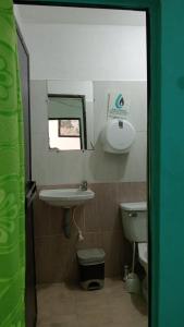 a bathroom with a sink and a toilet at Casa Hotel El Eden in Carepa