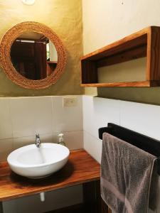 a bathroom with a white sink and a mirror at Las Cabañas de la Iguana in Ayampe