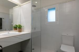 een badkamer met een glazen douche en een wastafel bij Apartamento Rosari II in Vilassar de Mar +10 foto's