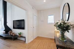 een woonkamer met een vaas met bloemen op een tafel bij Apartamento Rosari II in Vilassar de Mar