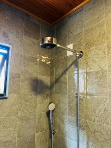 a shower with a glass door in a bathroom at Recanto Gamboa in Garopaba