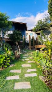 a garden with a stone pathway in front of a house at Recanto Gamboa in Garopaba
