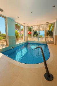 una piscina en una casa con una gran ventana en Hotel Neptun Gradac, en Gradac